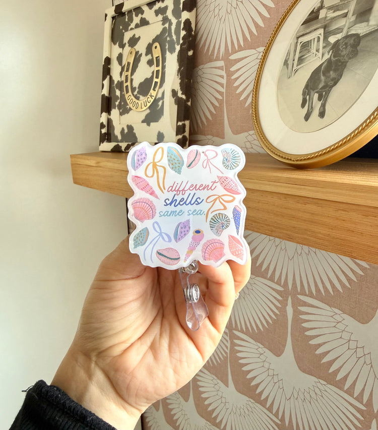 different shells same sea badge reel